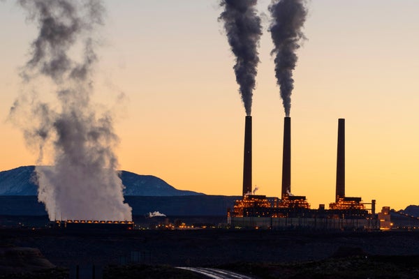Smokestacks emitting fumes at dawn